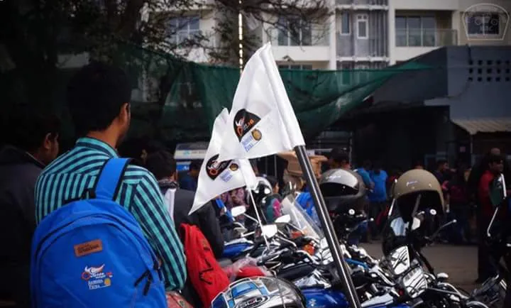 Printed Akshaya Patra Outride Hunger flags and a branded backpack at a motorcycle ride event