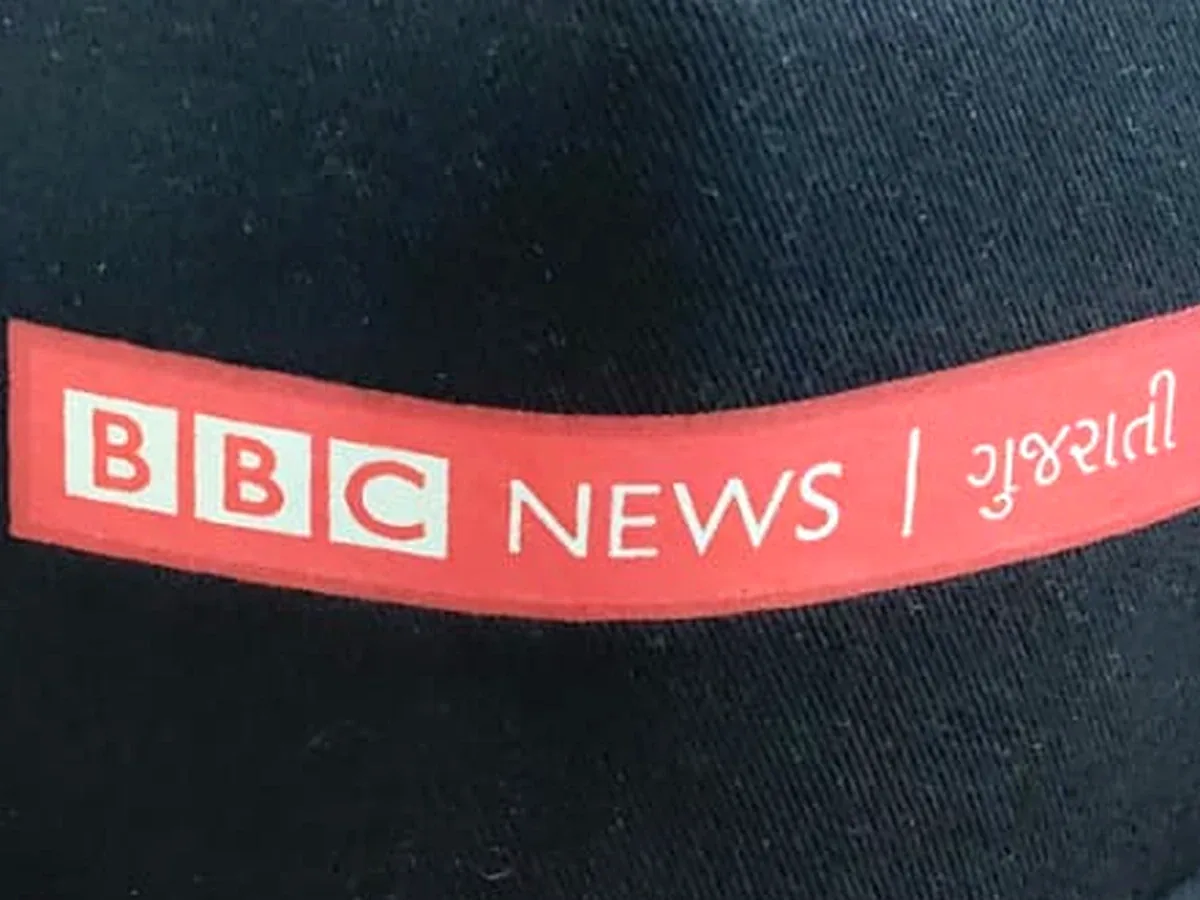 Close-up of the red BBC News Gujarati screen print on a black cap