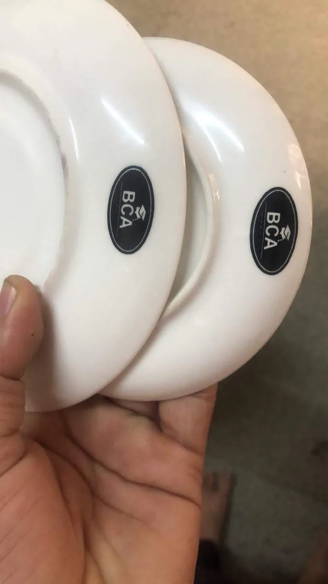 White ceramic saucers branded with the black oval BCA logo