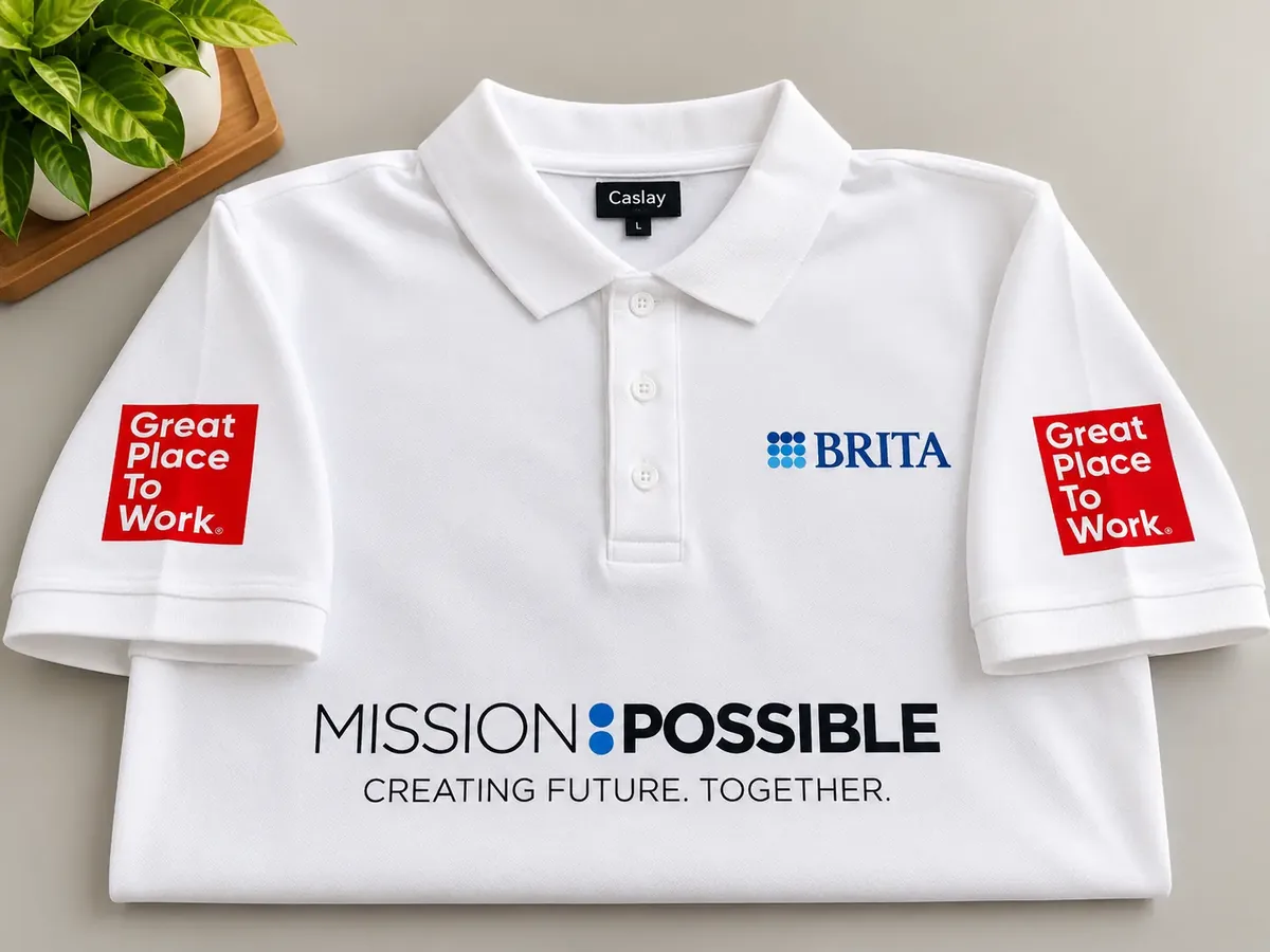 White BRITA polo T-shirt showing chest logo, sleeve badges and printed front slogan