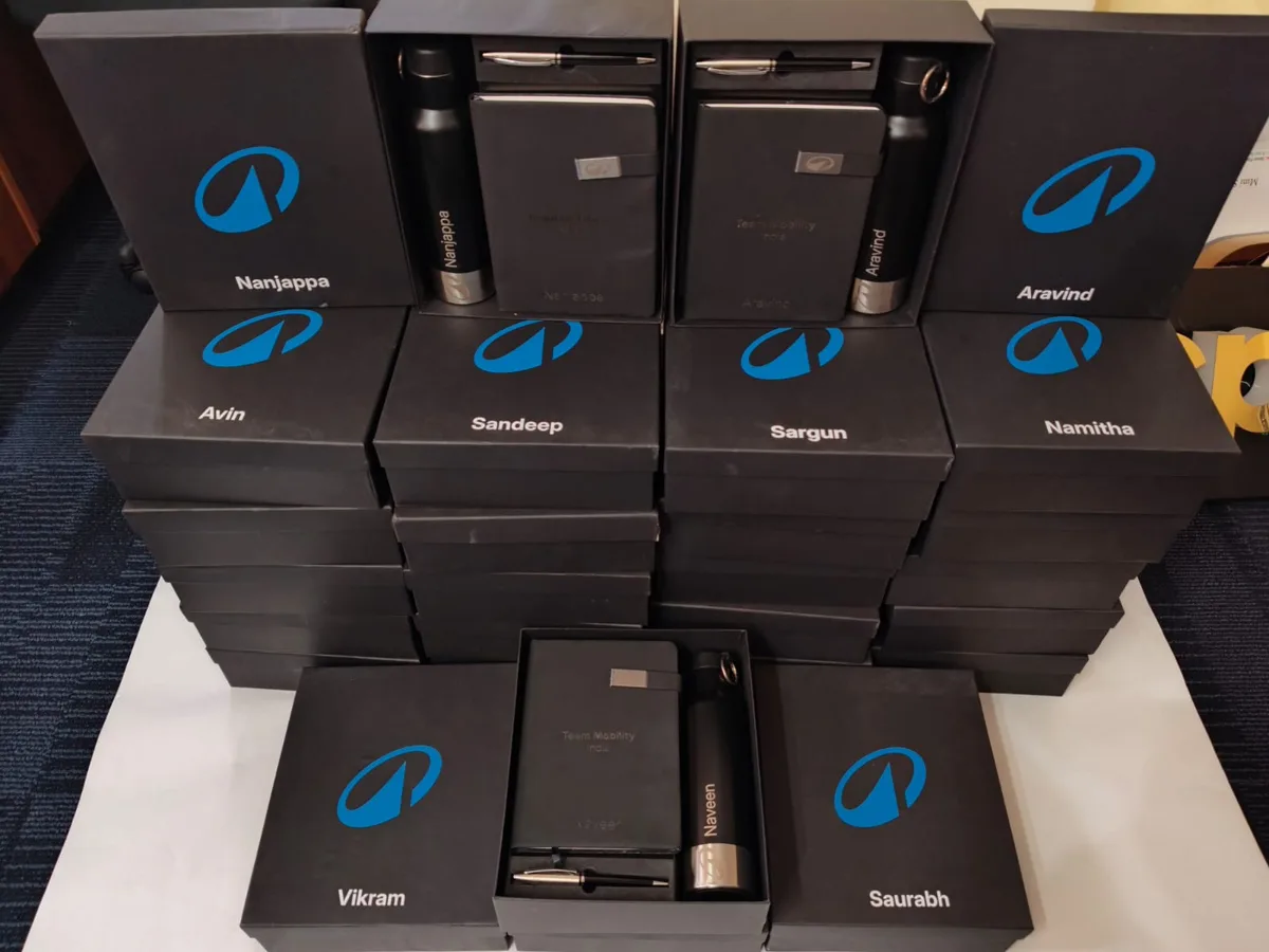 Stacked black Decathlon Anubhava gift boxes printed with the logo and individual employee names