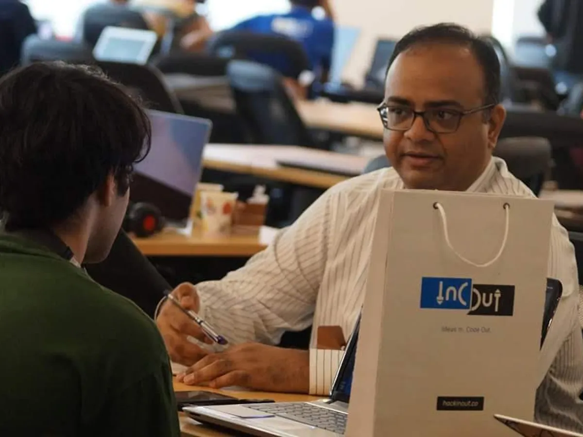 Devfolio branded paper bag beside a participant at the event