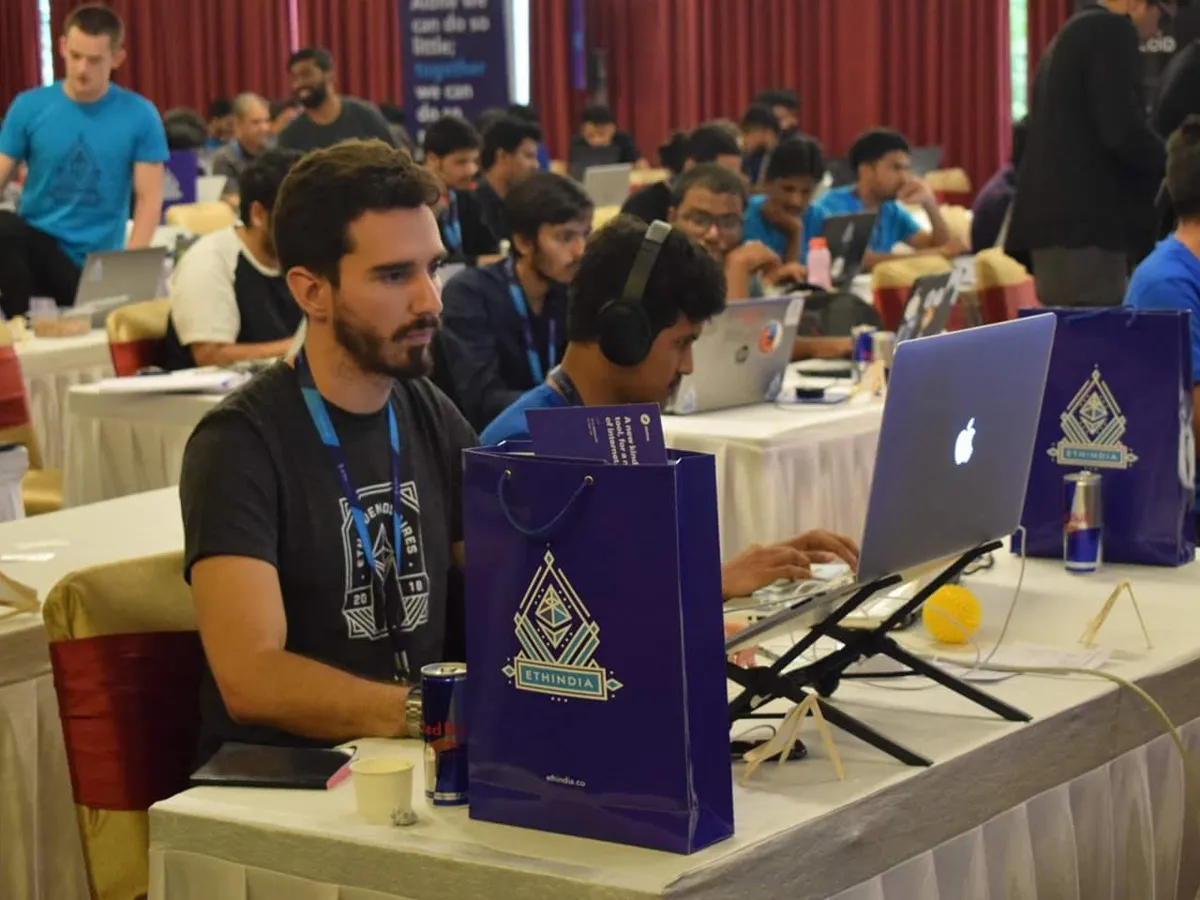 Devfolio branded paper bags and laptop stickers at the event