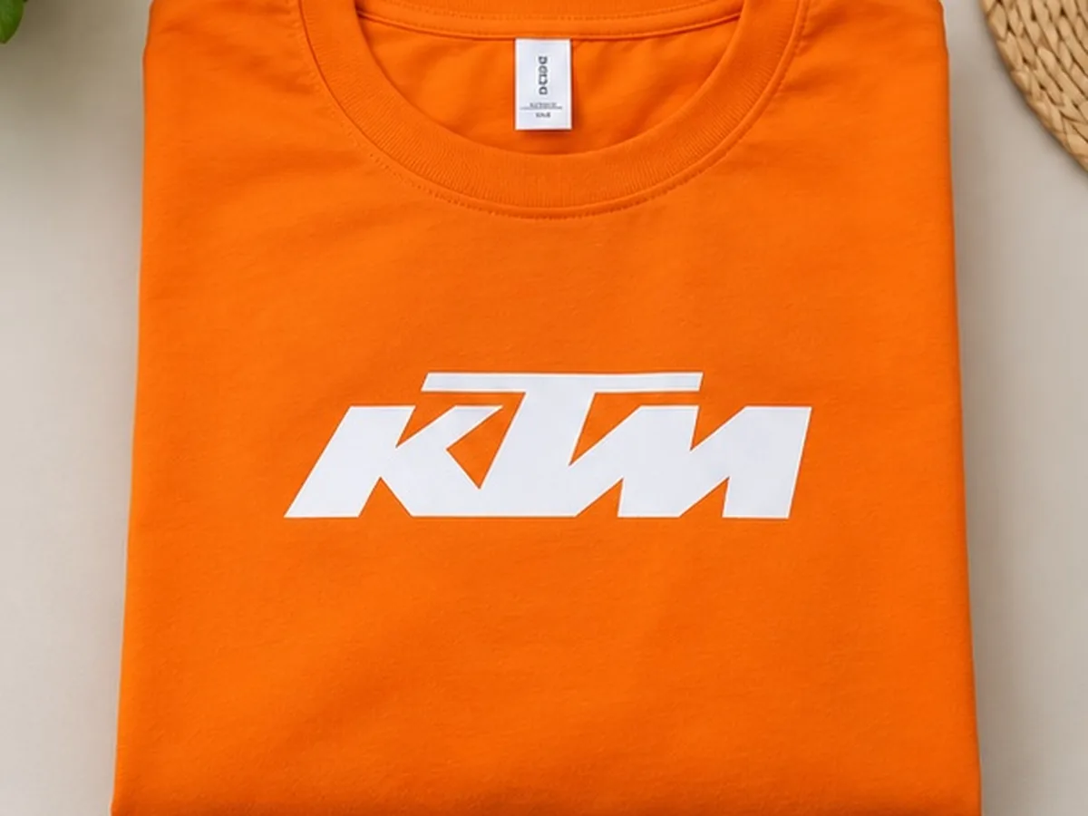 Folded orange KTM cotton T-shirt showing the screen printed chest logo