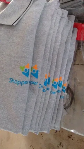 Stack of grey Shopper Crux cotton T-shirts with the screen printed chest logo