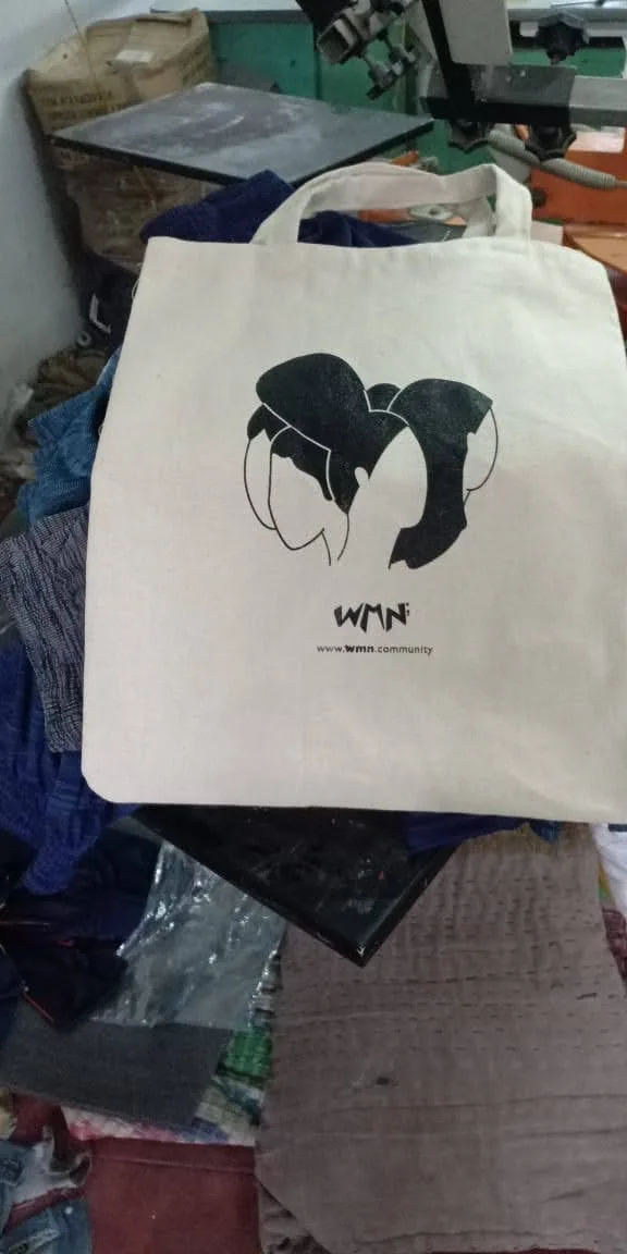 Natural cotton tote bag screen printed with the WMN community artwork